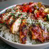 Overhead view of a vibrant Lemon Herb Roasted Chicken Bowl featuring tender herbs, bright roasted peppers, zucchini, and a zesty lemon dressing.