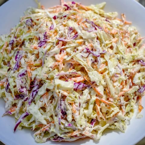 A bowl overflowing with chilled, colorful coleslaw, perfect as a vibrant summer side dish.