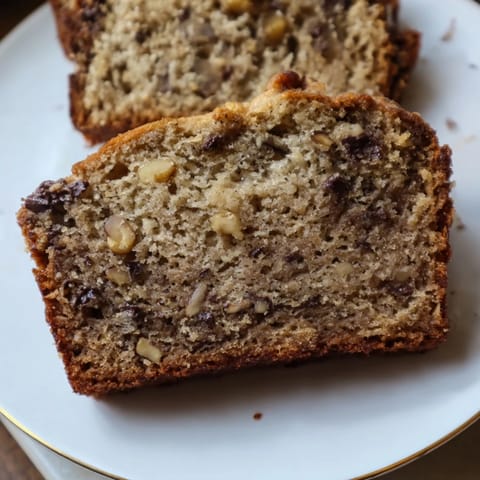 Warm, fragrant banana bread slices, pictured with a generous spread of butter, perfect comfort food.