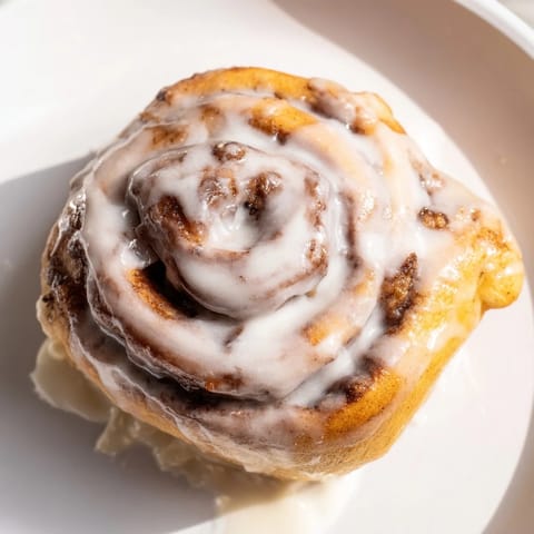 Warm, golden Cinnamon Rolls fresh from the oven, drizzled with sweet, creamy vanilla glaze.
