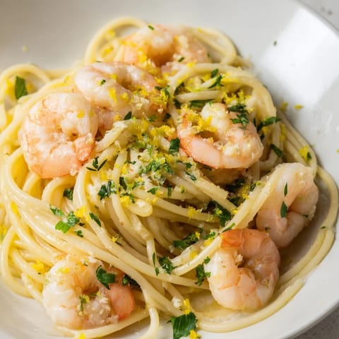 Tossed Lemon Garlic Shrimp Pasta features sautéed shrimp, garlic butter sauce, and a sprinkle of red pepper flakes.