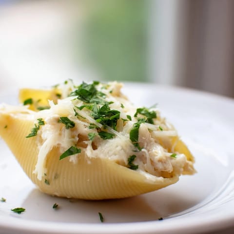 Jumbo pasta shells filled with creamy chicken Alfredo, baked until bubbling with melted mozzarella and Parmesan cheese.