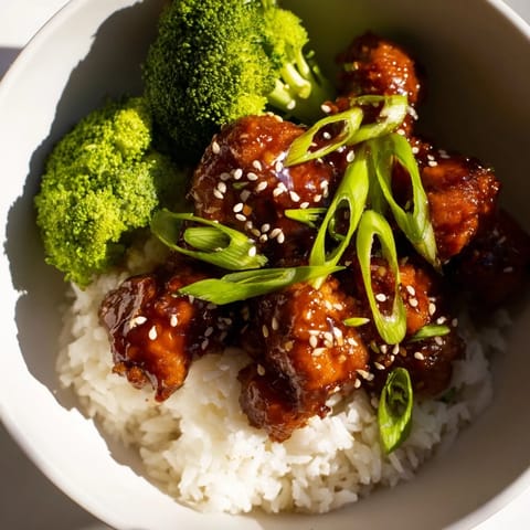 Golden-brown Sweet Chili Chicken pieces glistening in sauce, served over steamed rice and crisp broccoli.