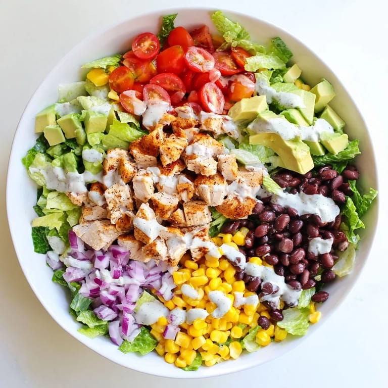 Freshly tossed Chicken Taco Chopped Salad topped with crunchy tortilla chips, avocado, and cheese.  