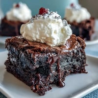 Festive 4th of July Firecracker Brownie Bites topped with creamy frosting and red, white, and blue sprinkles, perfect for patriotic celebrations.